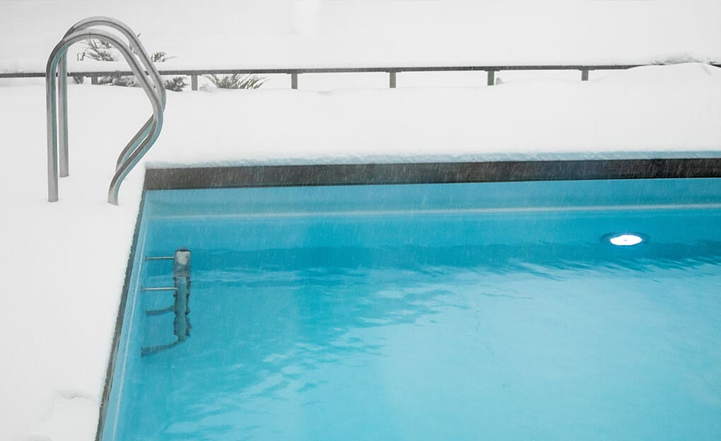 Piscine entouré de neige pendant l